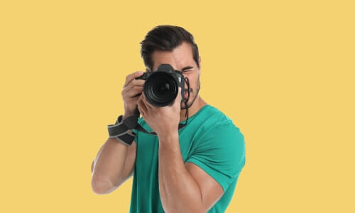 A photographer is holding DSLR om Ultimate Photography Bundle for Professional Photographer Training