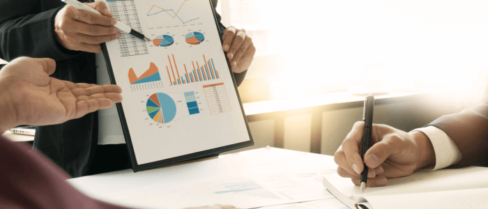 Project management team analyzing charts and graphs during a meeting, showcasing various data visualizations including pie charts, bar graphs, and line graphs.