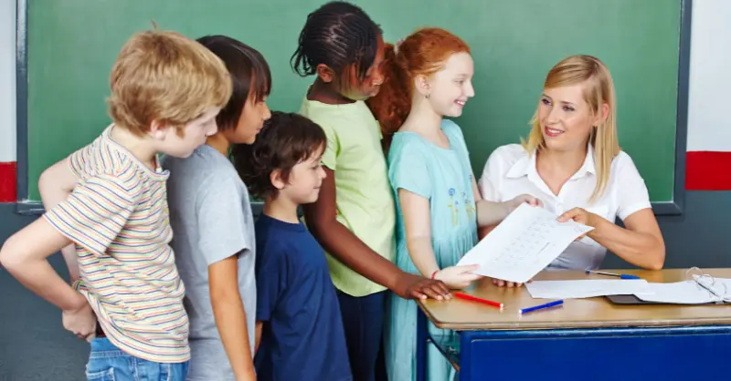 Primary Teacher engaging with students in a classroom setting